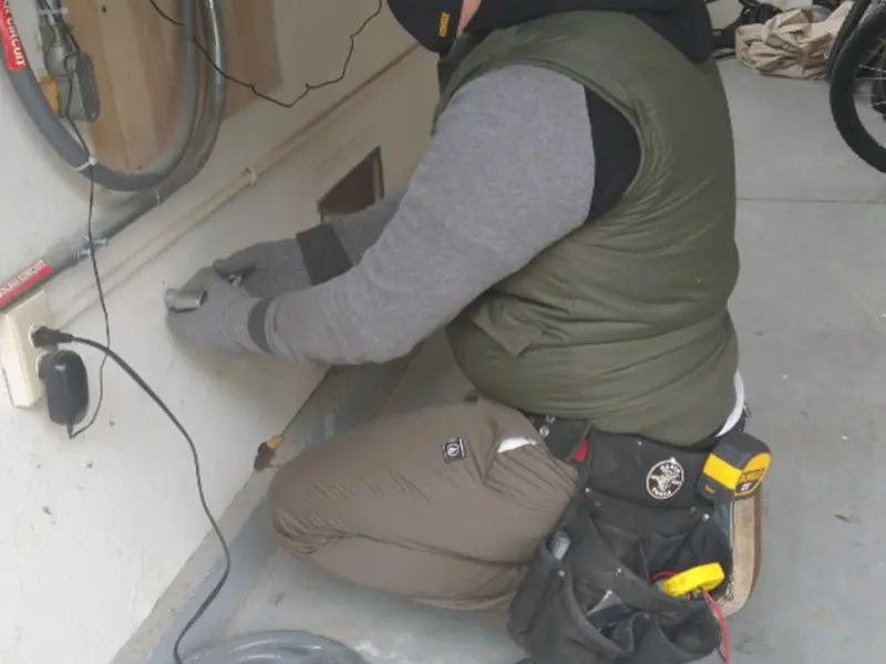 Electrician performing outlet wiring in a Willcox garage